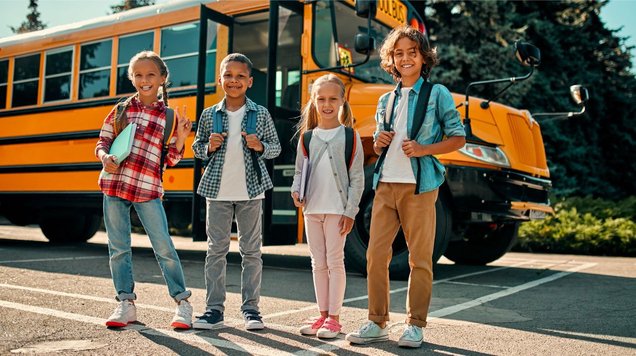 Kids standing outside of a school bus