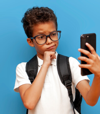 Boy holding a phone - Li and Liao Optometry